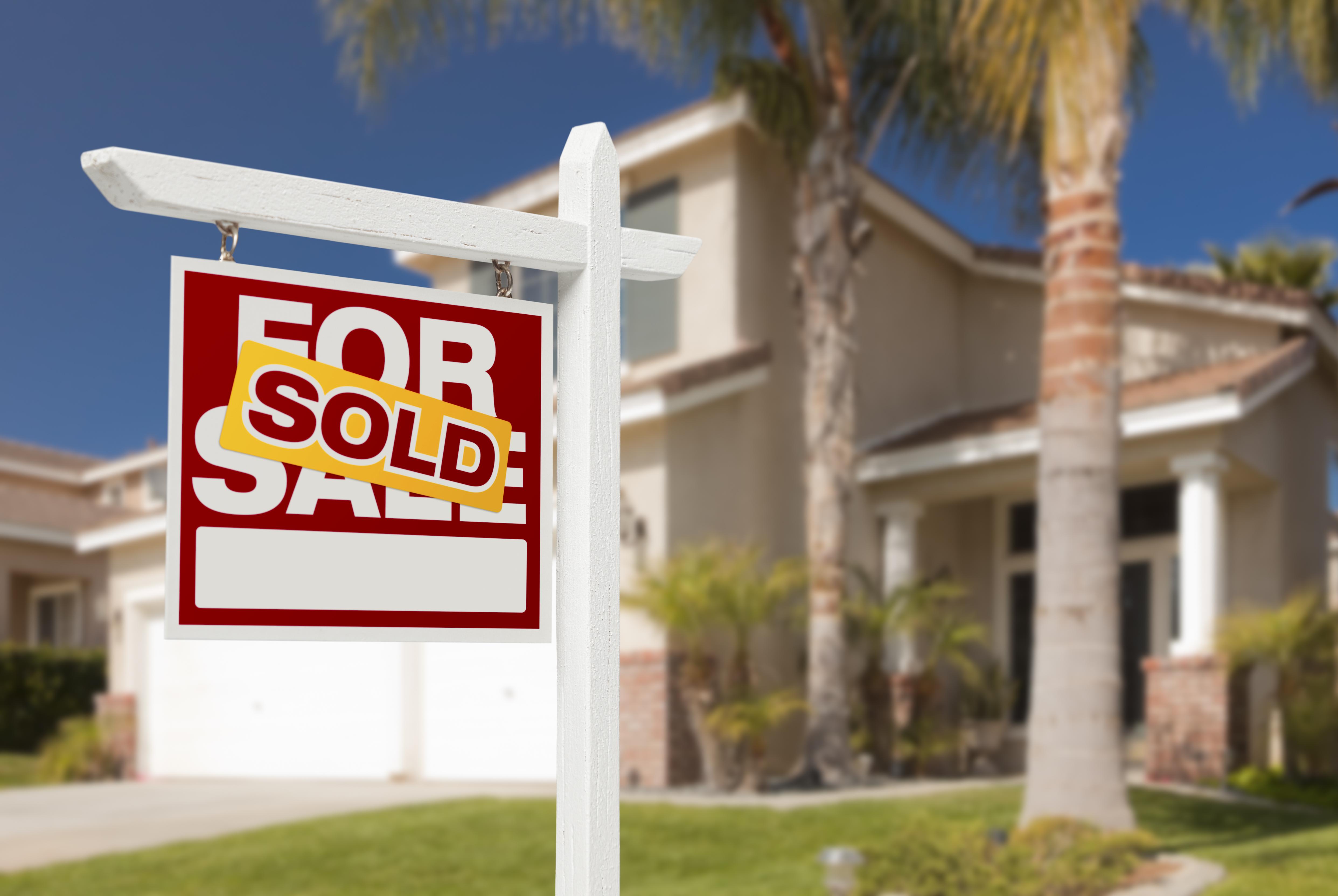 Sold Home For Sale Real Estate Sign in Front of Beautiful New House.