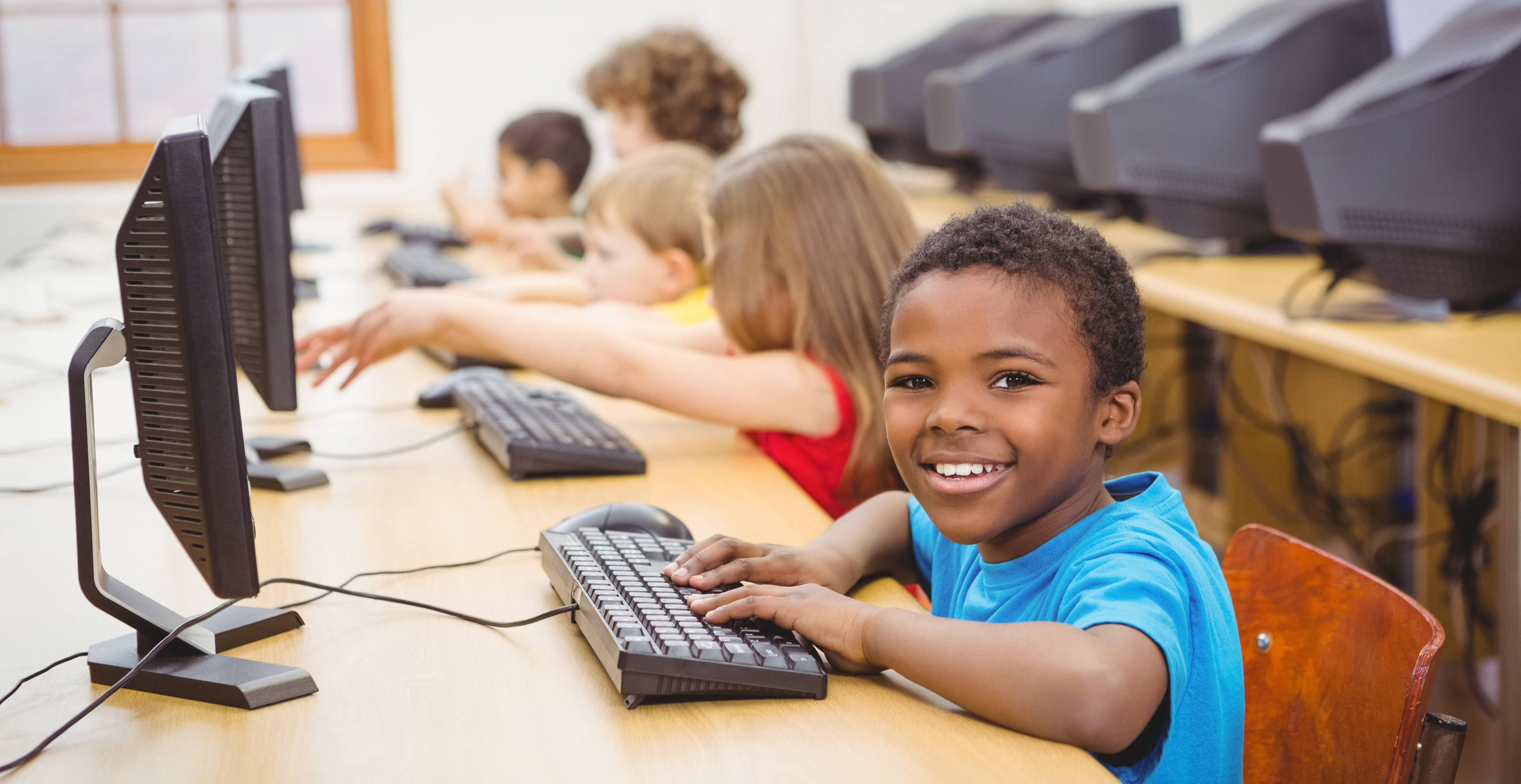 Smiling student using a computer at the elementary school