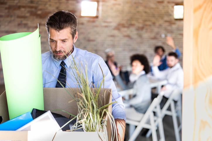Depressed businessman leaving the office after being fired.