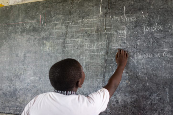 African child writing on school blackboard