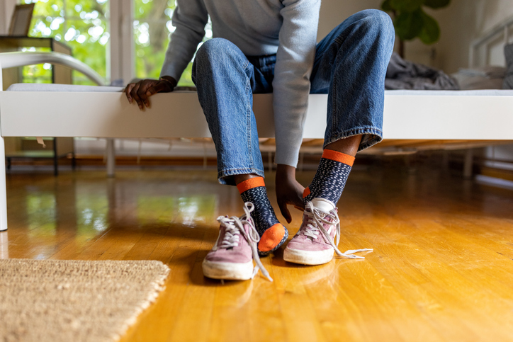 Unrecognizable woman Black ethnicity put her shoes on