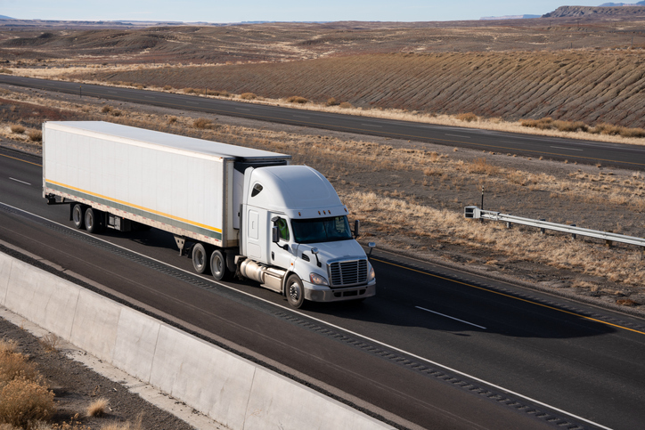 A White Semi Truck on I-70 Traveling West In Southern Utah on a Sunny Afternoon