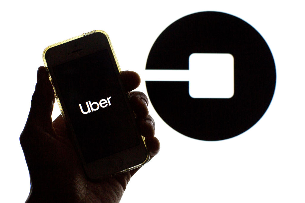In this photo illustration a Uber logo seen displayed on a...