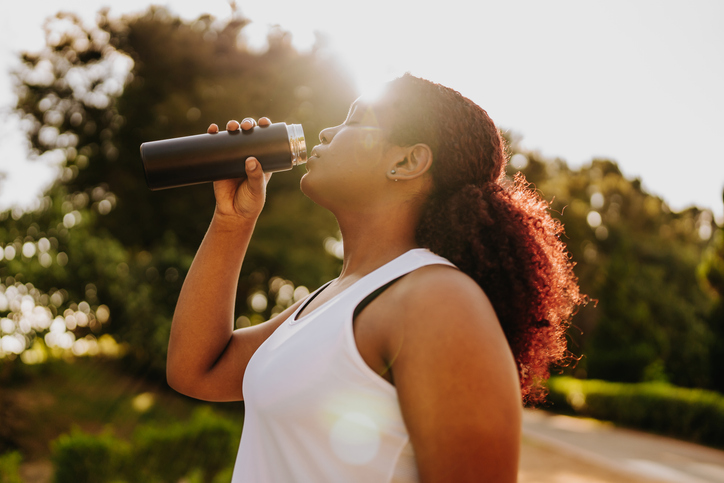Young fitness woman drinking water