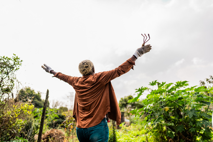 Rear view of a mature woman contemplating on a community garden