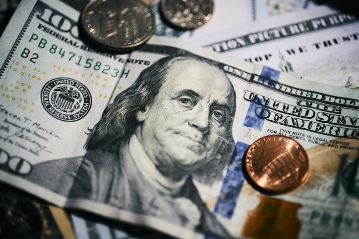Close-up of US currency bill and coins