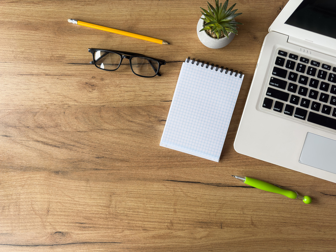 Workplace with laptop, empty notepad office supplies on office desk. Creative background